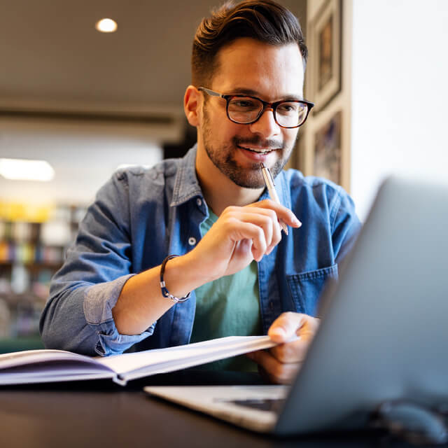 Educación uniminuto egresados Hombre trabaja en un computador
